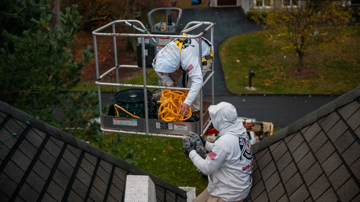 Gallo Bros crew installing holiday lighting from a lift